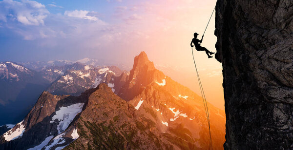 Silhouette Rappelling from Cliff