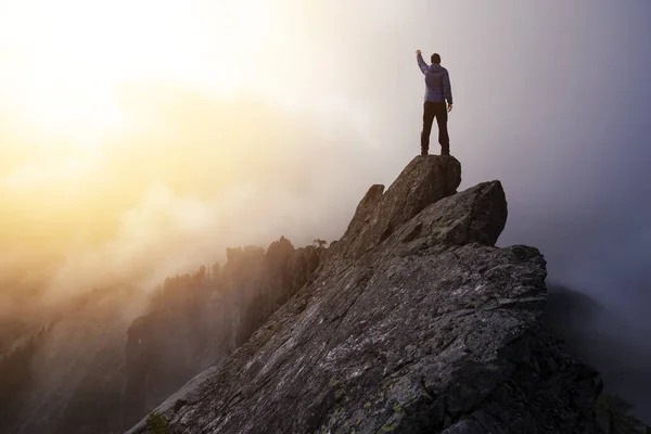 Abenteuerlustiger Mann wandert mit den Händen oben auf einer steilen Felswand. — Stockfoto