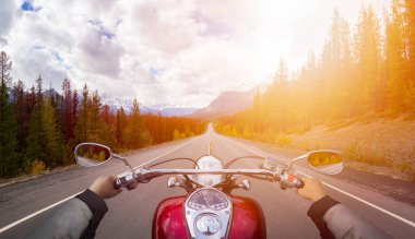 Biker Riding on a Motorcycle on a scenic Road clipart