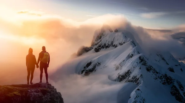 Fantasía aventura compuesta con una pareja sosteniendo las manos en la cima de un acantilado de montaña — Foto de Stock