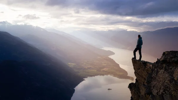 Fantasía aventura compuesto con un hombre en la cima de un acantilado de montaña — Foto de Stock