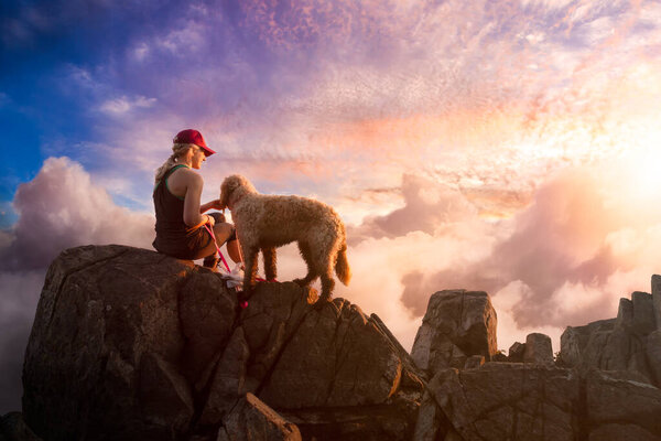 Adventurous Girl is hiking with a dog on top of Rocky Mountain