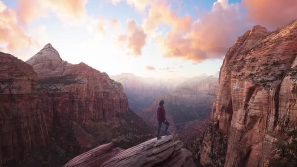 Kobieta pełna przygód na skraju urwiska spogląda na piękny krajobraz w kanionie — Wideo stockowe
