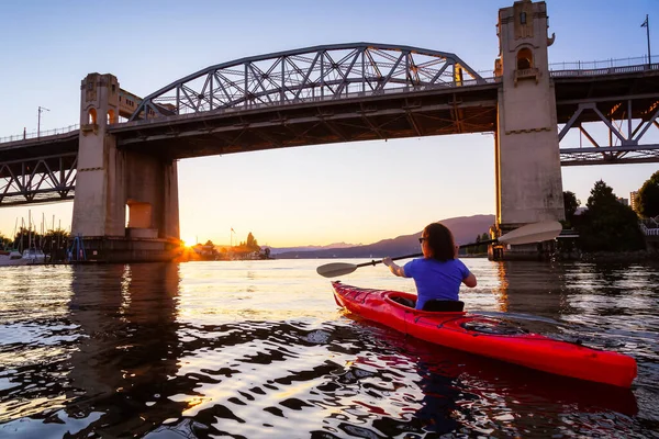 Chica Kayak en una ciudad moderna durante la puesta del sol — Foto de Stock