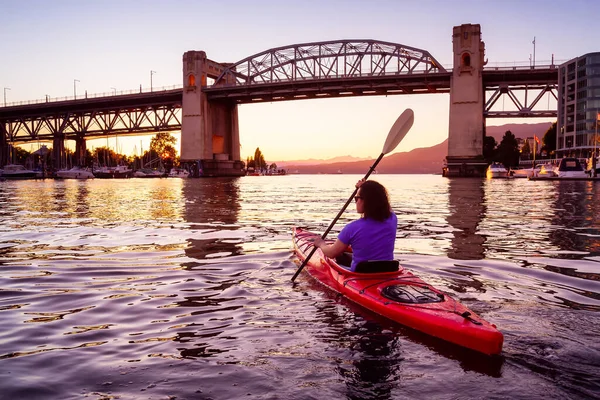 Chica Kayak en una ciudad moderna durante la puesta del sol — Foto de Stock