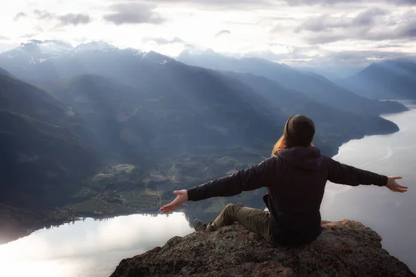 Composto de aventura de fantasia com um homem no topo de um penhasco da montanha — Fotografia de Stock