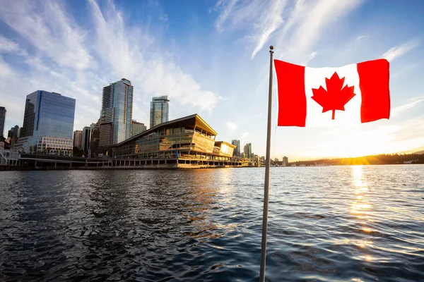 Национальный канадский флаг с современным центром города в фоновом режиме — стоковое фото