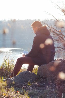 adam bir kitap okuma bir uçurumun oturuyor