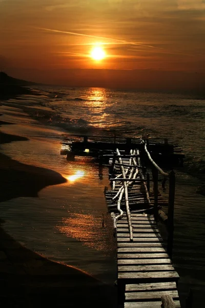 Puesta de sol sobre el mar y embarcadero — Foto de Stock