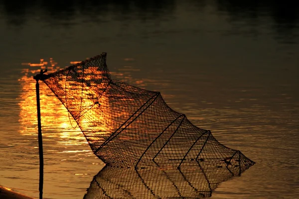 Pesca neta en el fondo de la puesta de sol iluminado wat — Foto de Stock