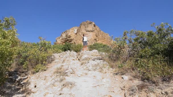 年轻女孩旅游。干沙漠山。一个女孩站在顶部，喜欢攀爬。有趣的跳转 — 图库视频影像