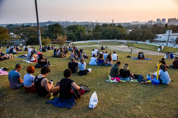 Pessoas relaxando na colina gramada — Fotografia de Stock