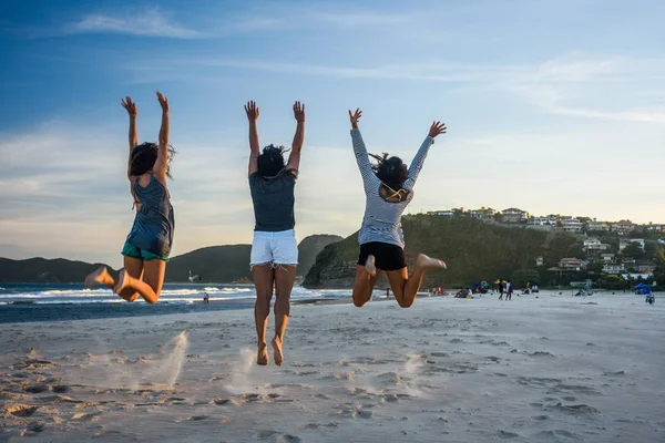 Три жінки стрибають на пляжі — стокове фото