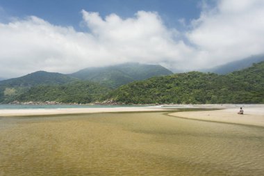 Kadın plajda yoga yapıyor. 