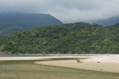 Kadın plajda yoga yapıyor. 
