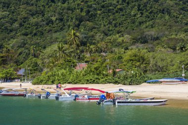 Taxi boats on the shore of tropical beach in Ilha Grande clipart