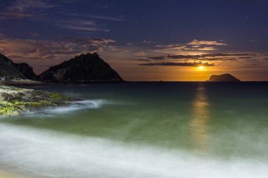 Rasa Sahili 'nde yükselen sarı dolunay, Armacao dos Buzios, Rio de Janeiro, Brezilya