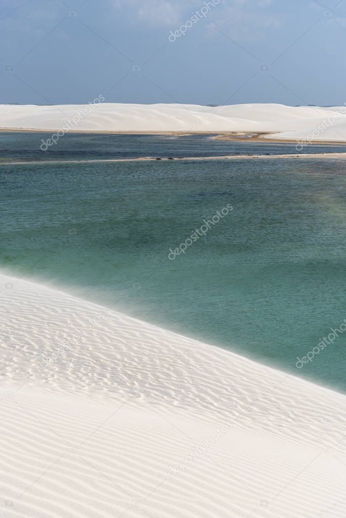 Beautiful view to white sand dunes and crystal clear rainwater lagoon in Lenis Maranhenses, Maranho, Brazil 