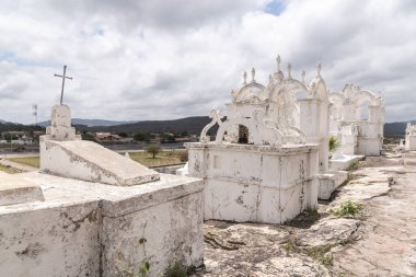Santa Izabel Mezarlığı, Mucug, Chapada Diamantina, Bahia, Brezilya 'da dağ yamacındaki beyaz Bizans tarzı mezar taşlarına güzel bir manzara