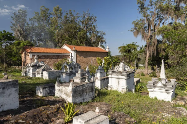 View to byzantine style white tomb stones on cemetery next to colonial old church in small historic countryside village, Chapada Diamantina, Bahia, Brazil