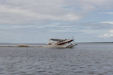 Manaus, Amazonlar, Brezilya yakınlarındaki Amazon 'daki sel basmış yağmur ormanlarından kalkan deniz uçağına bakın.