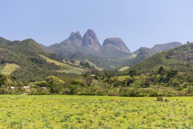 Tres Picos, Rio de Janeiro, Brezilya 'daki yeşil yağmur ormanlarının üzerindeki kayalık dağ zirvelerine güzel bir manzara