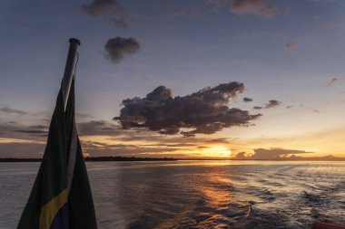 Amazon gün batımını seyredin manzarada tekne bayrağı, Amazonlar, Brezilya