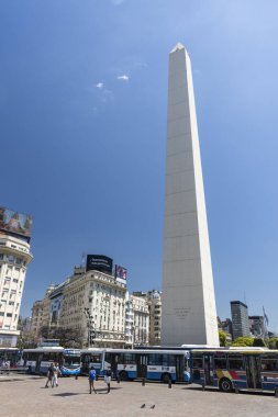 Buenos Aires 'in merkezindeki caddede tarihi dikilitaş ve otobüslere güzel bir manzara, Arjantin