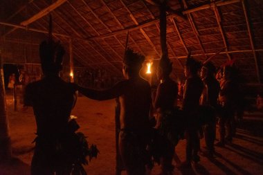 Amazon indigenous tribe inside traditional hut in the night, Amazonas, Brazil clipart