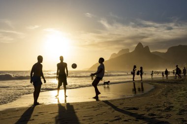 Sahilde futbol oynayan insanlar için Ipanema 'da güzel bir gün batımı manzarası, Rio de Janeiro, Brezilya