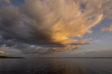 Güzel Amazon günbatımı Negro Nehri 'nin suları üzerinde renkli bulutlar, Amazonlar, Brezilya