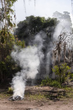 Bizans tarzı beyaz mezar taşları yakınında yanan duman küçük tarihi taşra köyü Chapada Diamantina, Bahia, Brezilya 'daki sömürgeci eski kilisenin yanında.