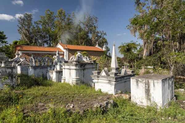 View to byzantine style white tomb stones on cemetery next to colonial old church in small historic countryside village, Chapada Diamantina, Bahia, Brazil