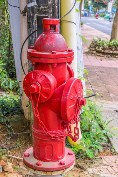 Red fire hydrant on a street near the sidewalk