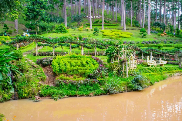 Diseño paisajístico del relajante jardín tropical con estatuas a orillas de un río — Foto de Stock