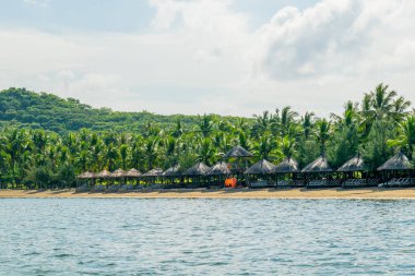 Güneş şemsiyesi ve avuç içi ile bir tatil tropikal plaj