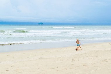 İki kardeş, beyaz kum üzerinde yürüyen çocuklar bir plaj, Vietnam, Nha trang denize yakın: