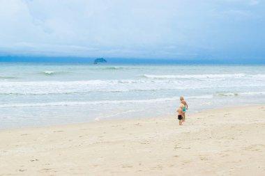 İki kardeş, beyaz kum üzerinde yürüyen çocuklar bir plaj, Vietnam, Nha trang denize yakın: