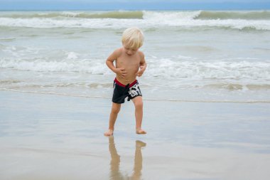 Deniz kıyı (beach), Nha Trang, Vietnam, suda yürüyen bir sarışın mutlu çocuk (çocuk)