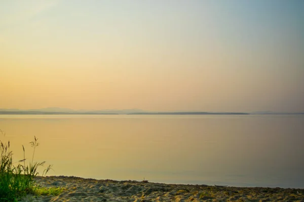 Pôr do sol dourado em uma costa de um lago com silhueta de plantas, Uveldy, o Ural, Rússia — Fotografia de Stock