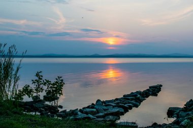 Romantik taş rıhtım, gün batımı, Uveldy, Urallar, Rusya, gölde bir geçit