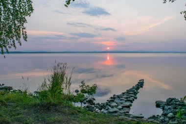 Romantik taş rıhtım, gün batımı, Uveldy, Urallar, Rusya, gölde bir geçit