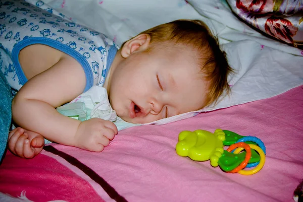Spící baby boy tvář dolů doma s hračkou — Stock fotografie