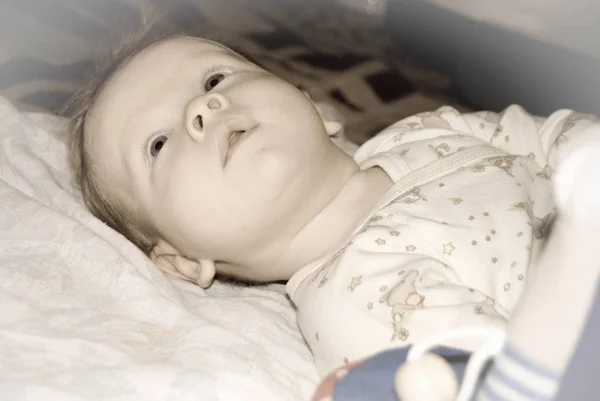 Un retrato facial de un niño en una cama mirando con interés — Foto de Stock