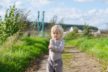 Kalan Seriouse sarışın çocuk kendini kollarıyla kucakladı