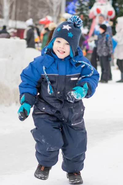 Niño feliz corriendo en un parque de invierno, Año Nuevo, Navidad —  Fotos de Stock