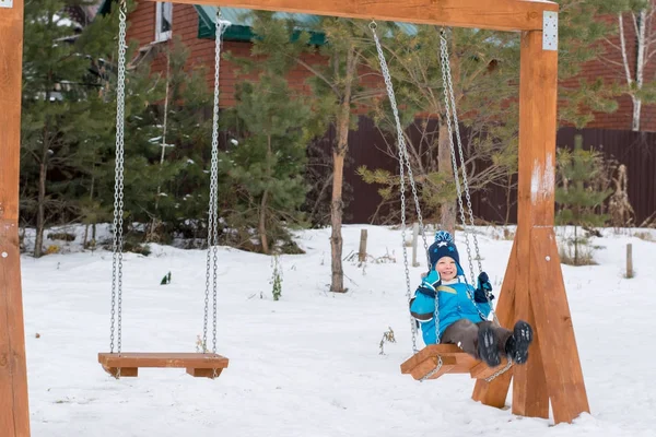 겨울 공원에서 그네에 행복 한 아이 스톡 사진