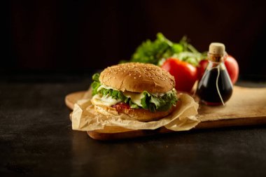 Siyah ahşap masadaki malzemeli hamburger.