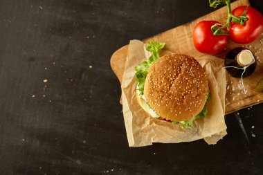 Siyah ahşap masadaki malzemeli hamburger.