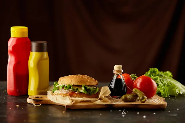 Burger with the ingredient on the black wooden desk